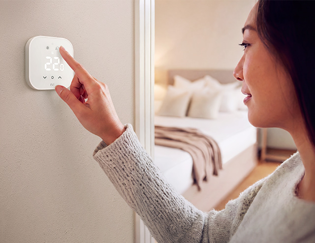 Eve Thermostat: Frau aktiviert Eco Mode, der hilft Heizkosten zu sparen